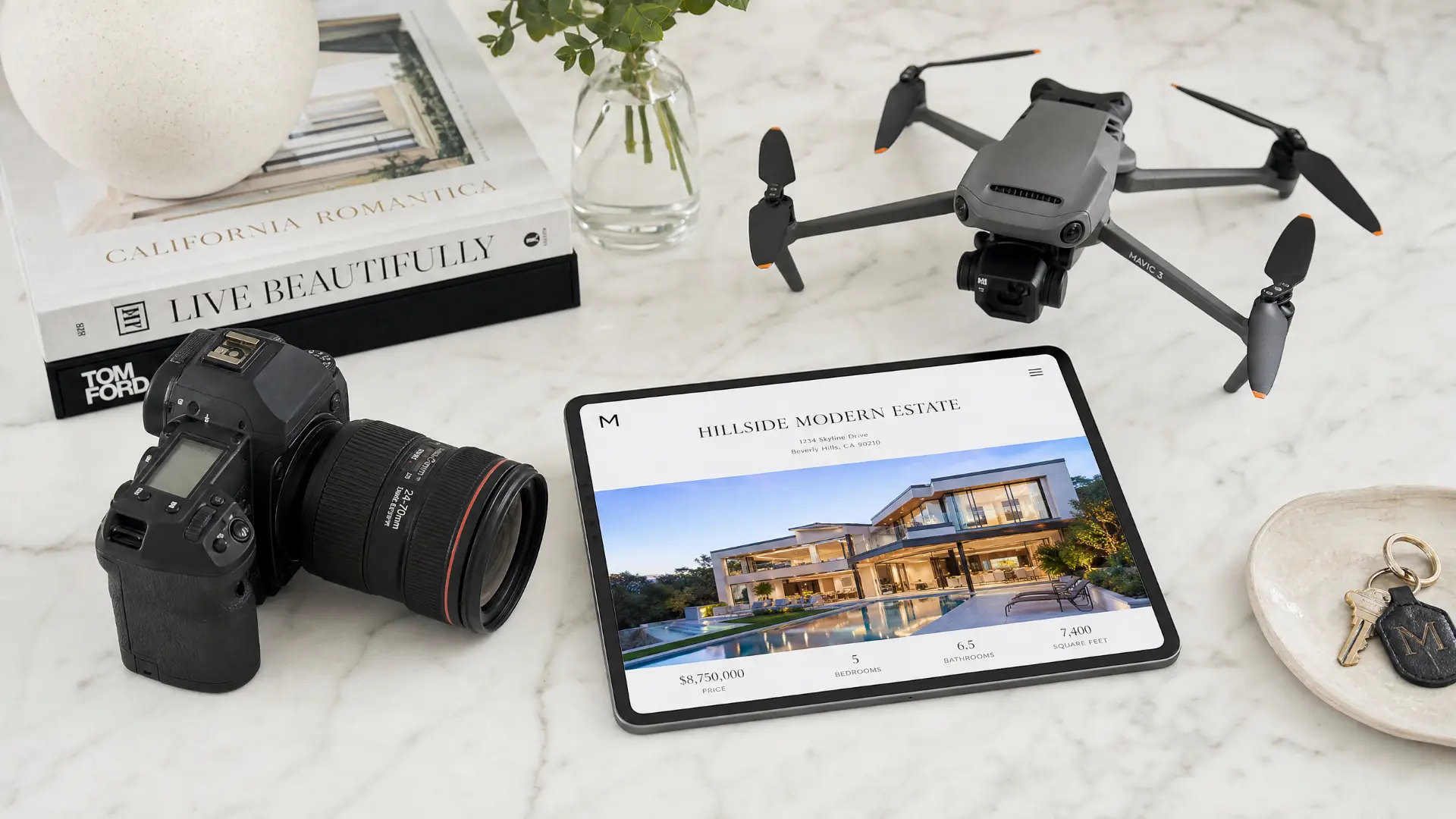 Professional real estate marketing toolkit including DSLR camera, drone, and tablet displaying a luxury listing